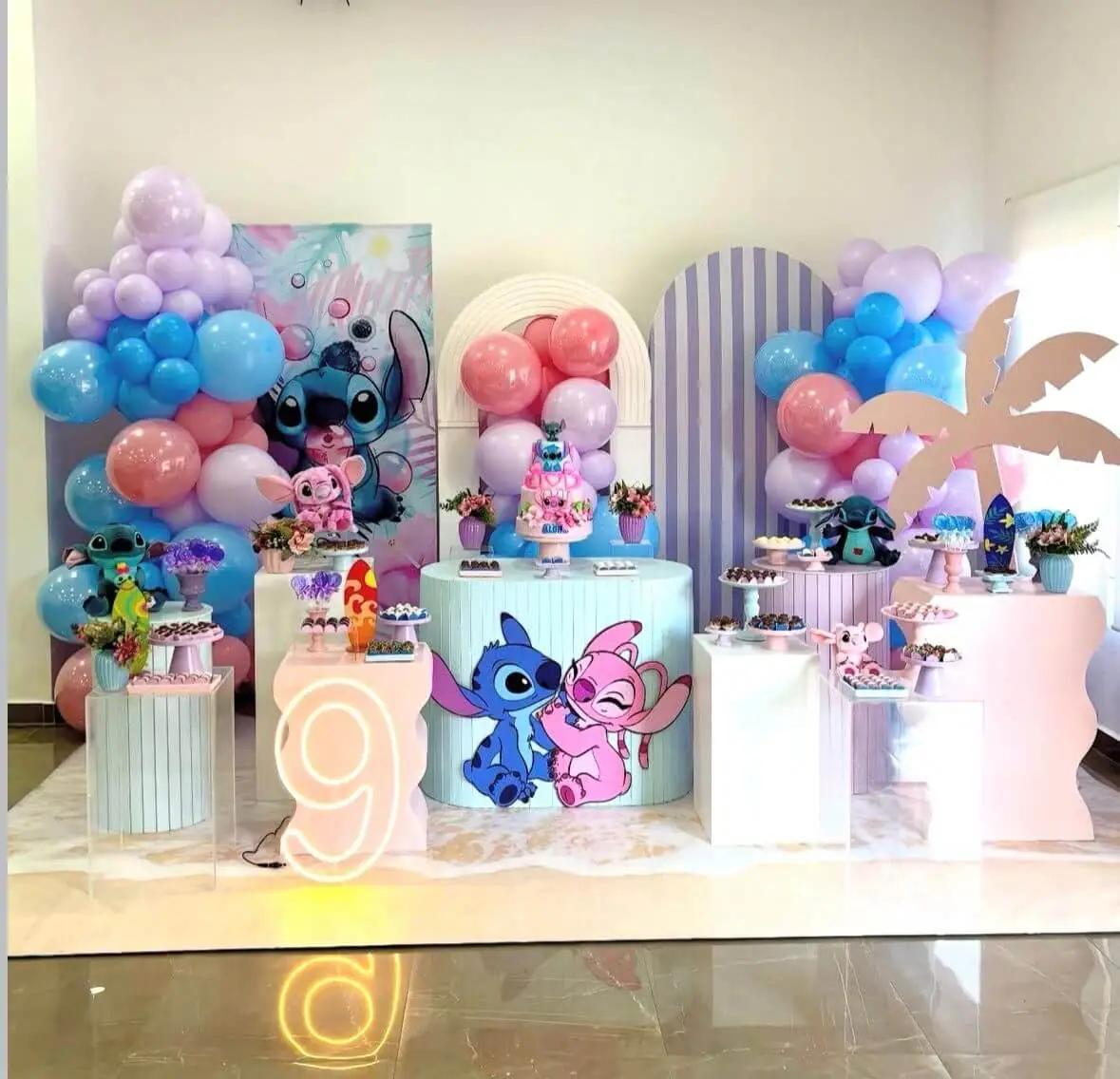 Composição de balões em tons azul, lilás e rosa em comemoração temática