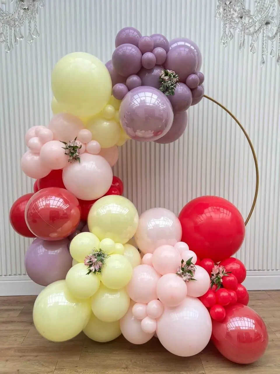 Balões lilás, amarelos, rosas e vermelhos em estrutura de arco